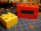 The LEGO LCD and another Quatro system brick. The squares on the grid underneath them are one inch on a side; the coin is a US quarter.